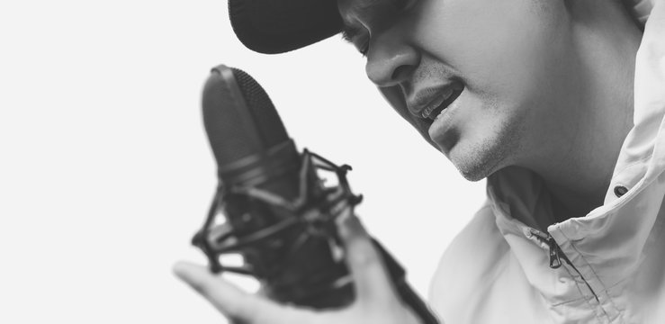 closeup portrait of asian male handsome pop singer singing with condenser microphone, black and white film tone
