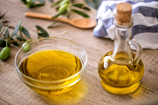 Extra virgin healthy Olive oil on wooden background.