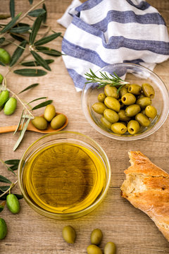 Italian food background with ciabatta bread, olive oil and olives over of wooden table background.