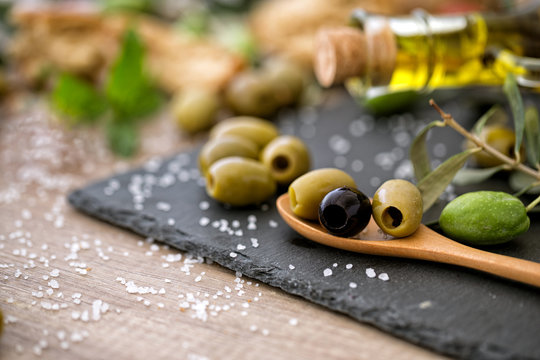 green and black healthy olive on the wooden table.