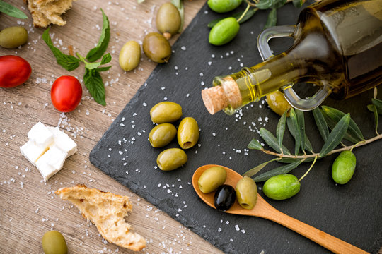 antioxidant green olives in black plate.