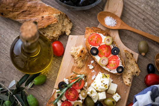 healthy bruschetta on wooden cutting board with vegetables.