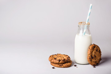 bottle of milk is decorated with cookies crumbs and chocolate chip cookies  - Powered by Adobe