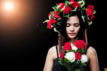 The abstract art design background of beauty lady is  wearing rose crown on head,turn face down to looking rose bouquet in hand,Lens flare effect,