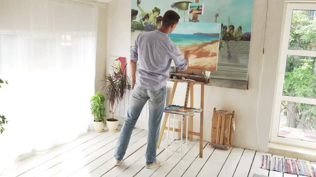 male painter paints landscape on canvas