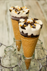 Ice cream cornetto.  Ice cream waffle cone vanilla and chocolate on rustic background