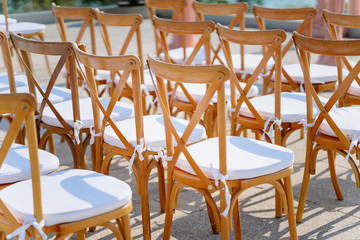 Close-up back side of wooden folding lawn chairs in a row settings for outdoors wedding venue on terrace