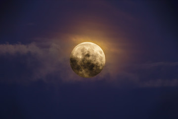 Fototapeta na wymiar Bright full moon against dark clouds
