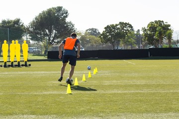 Soccer player dribbling through cones