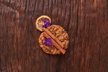 Chocolate Cookies near flower on the background of oak. Healthy morning breakfast concept. Minimalist. Spring food flat lay