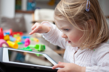 Female toddler playing on a tablet