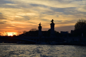 Sunset on the Seine River in Paris with the Pont Alexandre III in silhouette
