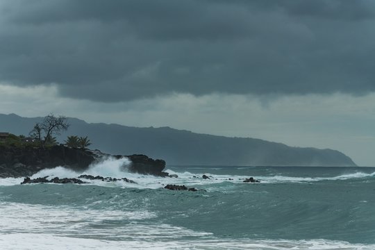 Fototapeta Waves of sea crashing at rocky coastline
