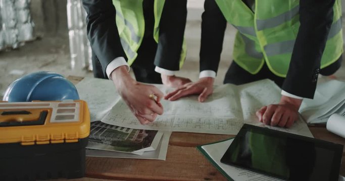 Closeup two experts engineer making plan of construction site