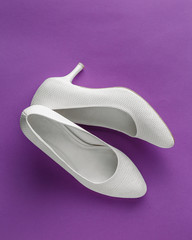 White wedding shoes on purple background
