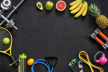 Sports equipment and organic food on black background. Top view. Motivation
