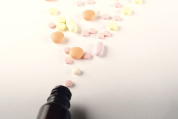 Close up of heap of pills with pill bottle