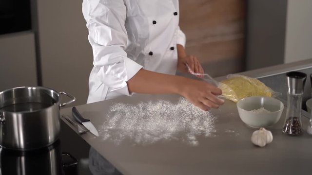 4K female cook preparing dough for gnocchi on kitchen worktop
