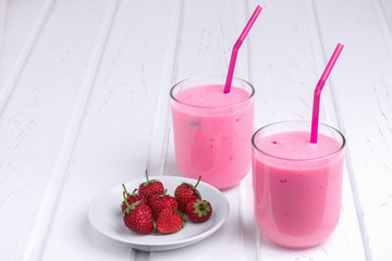 Natural yogurt with strawberries on white table