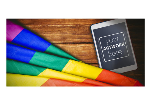 Overhead view of rainbow flag with digital tablet on wooden table