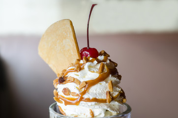 ice cream sundae with cherry and wafer topping