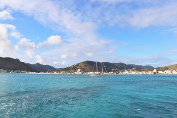 Sailboat on the ocean with a tropical island in the background