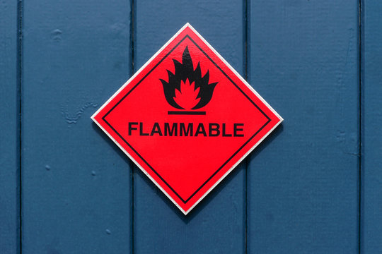 Red diamond shape flammable warning sign on a blue door
