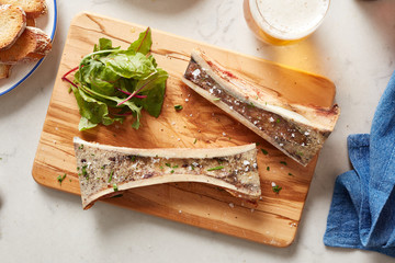 Top view of marrow bones with lettuce on board.