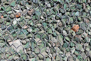 Background from stones and pebbles in wire mesh / Stone texture from wire mesh filled with stones 