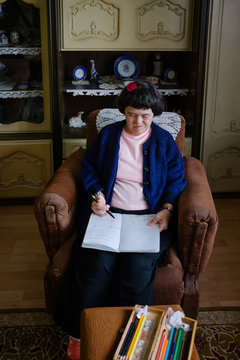 Female with down's syndrom writing at notebook