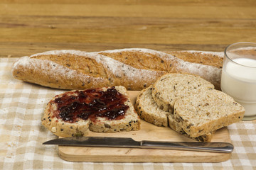Morning easy breakfast, bread, jam , and cornflakes on wooden background
