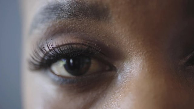 close up african american woman eye blinking looking at camera reflection on iris