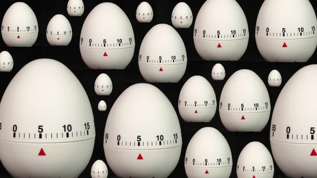 Many White Kitchen Egg Timers Of Different Sizes On A Black Background Counting Down To Zero Time Lapse.