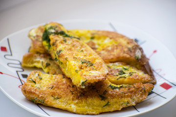 Fried bread in an egg with dill. Fried bread on a plate. Breakfast - bread and eggs.