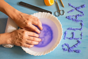 Manicure at home. Woman dipping her hand in a bowl of water. Nail Care.