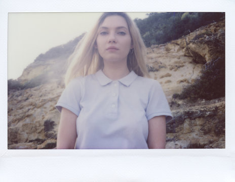 Pretty girl in t-shirt looking at camera over mountain flack.