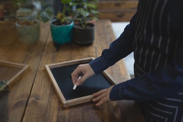 Barista writing on slate with a chalk