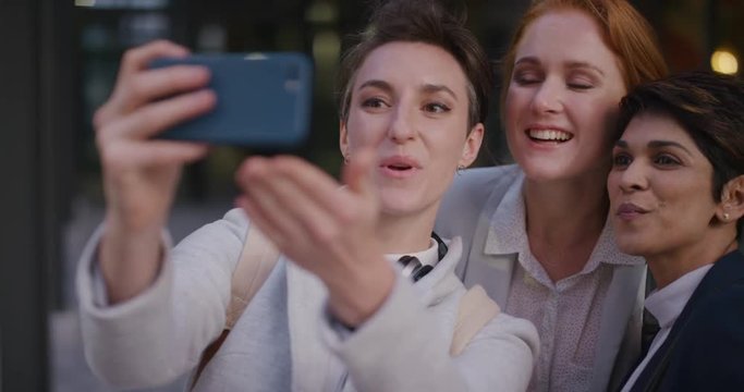 portrait young multi ethnic group of women friends taking selfie photo using smartphone enjoying happy urban lifestyle friendship in city relaxed female colleagues having fun slow motion