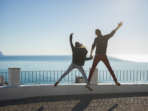Couple jumping at seaside