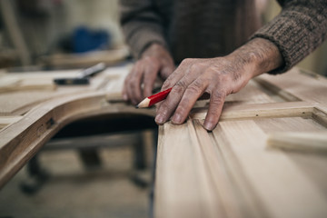 Close up shot of old master carpenter working in his woodwork or workshop