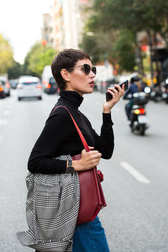 Stylish short haired business woman commuting between meetings on a busy city