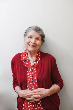 Portrait of content senior woman on plain white background