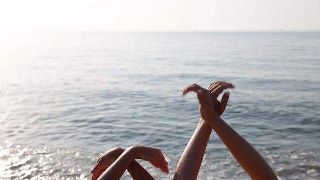 Freedom concept. Woman and child making hands like flying birds at bright sunny blue sea water and sky background. Hands moving in gesture as wings of doves or gulls. Real time full hd video footage.