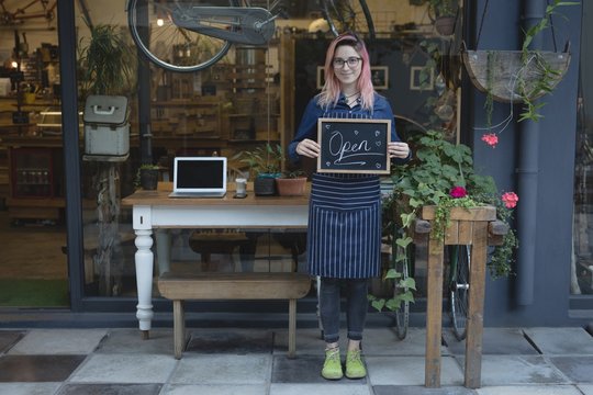 Barista standing with a open signboard