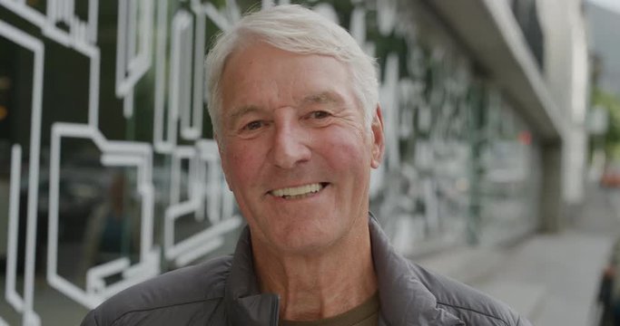 portrait of cheerful middle aged caucasian man smiling happy looking at camera enjoying relaxed retirement confident satisfaction city street background