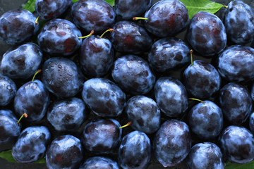 Ripe fresh plums sprayed with water used as background