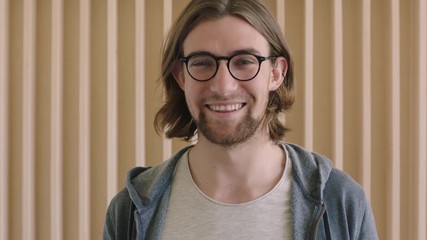 close up portrait of cute geeky man wearing glasses smiling happy enjoying success lifestyle relaxed attractive male indoors