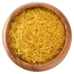 Curly pasta in a round wooden bowl isolated on white background, top view