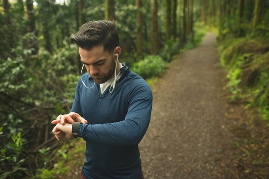 Handsome man checking time on smartwatch