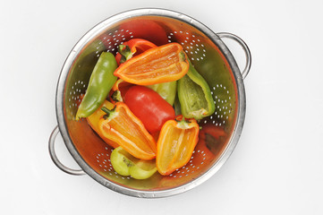 Sweet pepper in a colander after heat treatment. White background. Close-up. View from above.